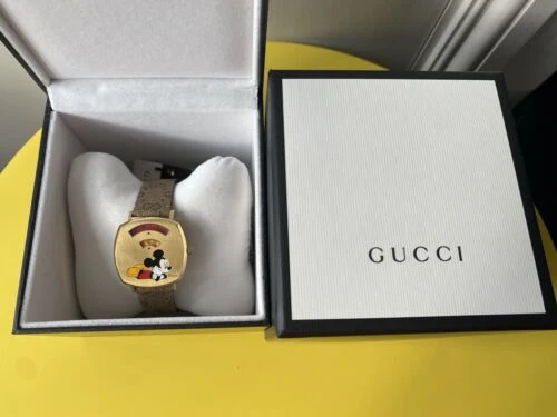 5bb8f124-dfca-426f-8754-dd99d419a4cc_b60e8edc-e370-4aab-b646-2fc1cb6abc04 Gucci Grip Disney Mickey Mouse Gold Dial Brown Leather Strap Watch For Women - YA157420